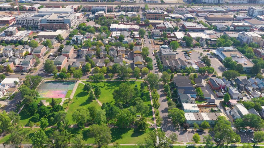 Johannesburg, South Africa, panoramic aerial footage overlooks mature green tree cover, detached houses, tree-lined city streets, and busy commercial districts reaching toward the horizon.