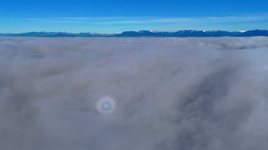 Sunrise above a sea of clouds with atmospheric glory — aerial view