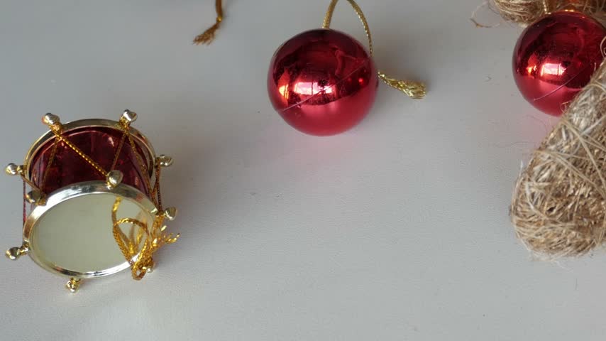 Christmas tree decoration with lights with lights made out of fibers on white table next to other festive decorations.