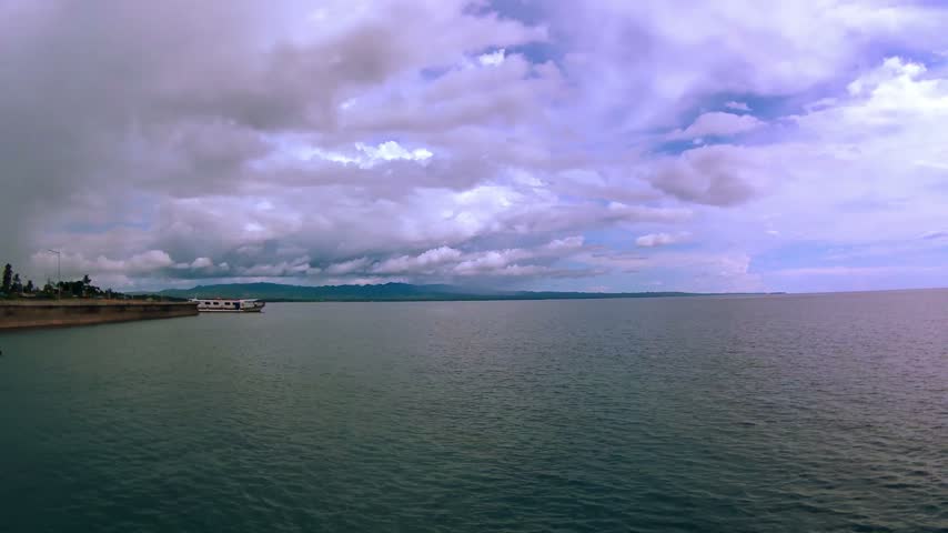 Sea, horizon, island, mountain, embankment. Clouds.