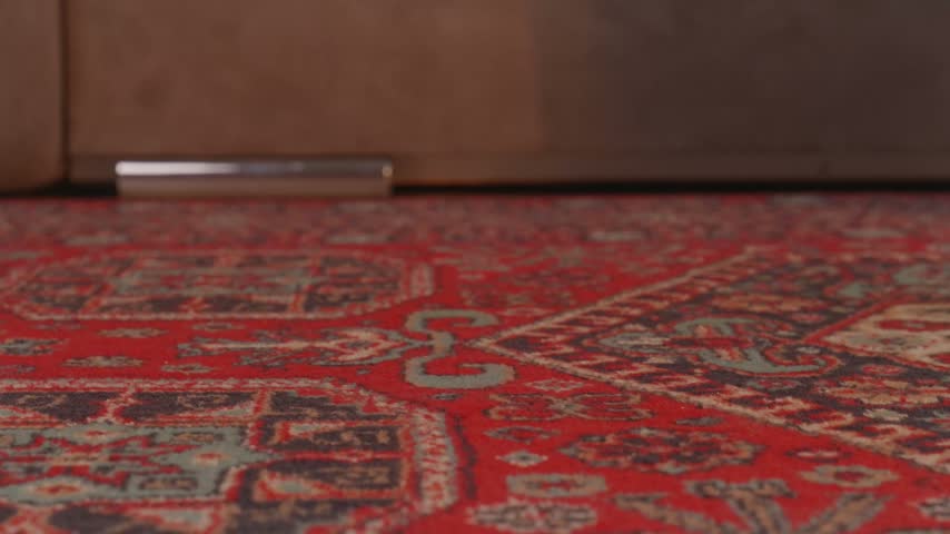 A close-up side view shot of a person walking across the room in brown suede orthopedic clogs with a cork sole and stopping for a moment to highlight foot comfort and ergonomic support.