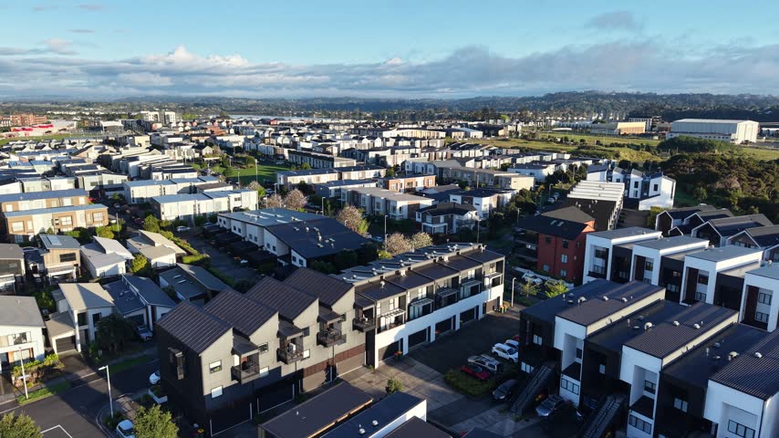 Aerial drone flyover of modern suburb with townhouses, streets and parks, Hobsonville Point, Auckland, New Zealand