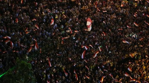 CAIRO, EGYPT - 2013: Crowds protest at a nighttime rally in Tahrir Square in Cairo, Egypt.