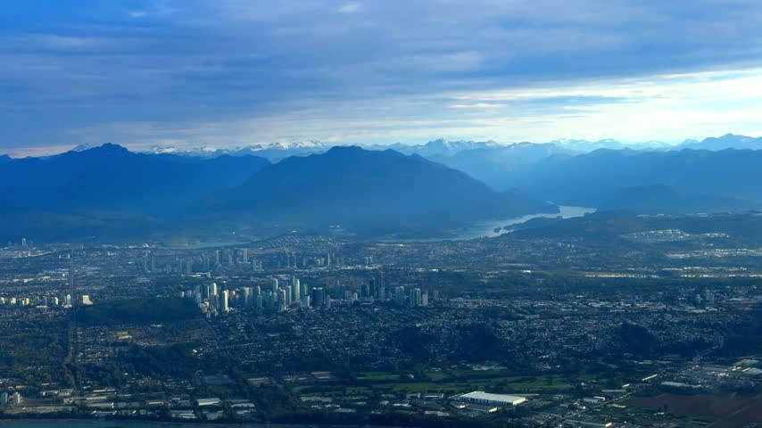 Scenic aerial view from an airplane window flying high above the city of Vancouver and the surrounding mountains in Canada