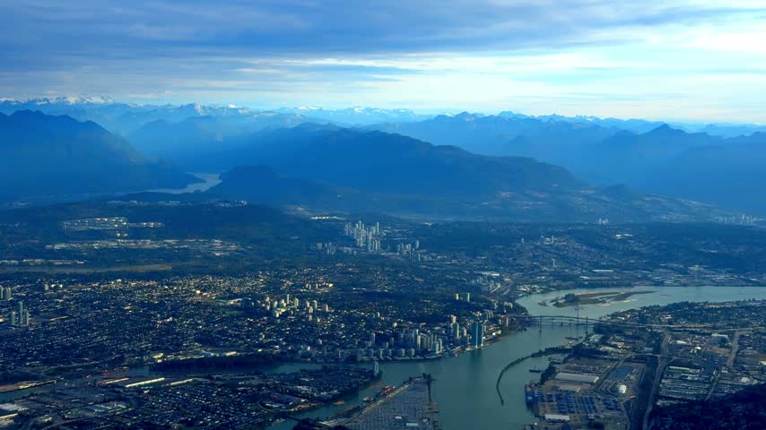Scenic aerial view from an airplane window flying high above the city of Vancouver and the surrounding mountains in Canada