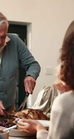 Thanksgiving, turkey and old man serving family in home with conversation, gathering and lunch food. Happy senior person, hosting and tradition in dining room with meal, cut meat and dish for people.