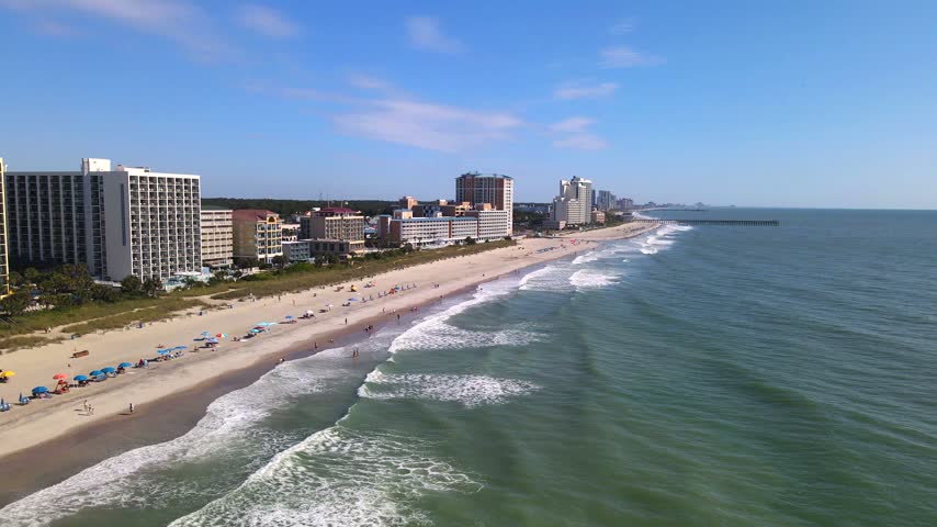  broad Atlantic expanse borders the hotel lined shoreline beneath an oblique aerial view.