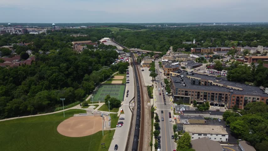 Descending Train shot Aerial Village of Wauwatosa Wisconsin in the Milwaukee region. Restaurants on the river.	