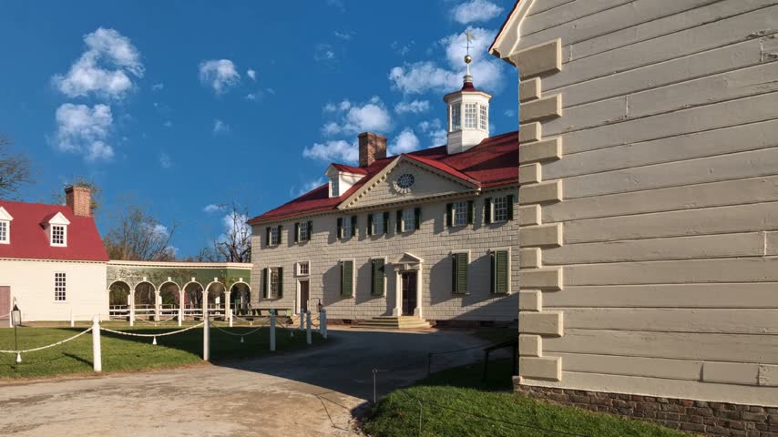Symmetrical front view of Mount Vernon, the historic estate of George Washington in Virginia, featuring the iconic mansion, manicured lawn, and dramatic overcast sky. Mount Vernon, VA, USA - July 6, 2024: George Washingtons Mansion at mount Vernon on a sunny summer day