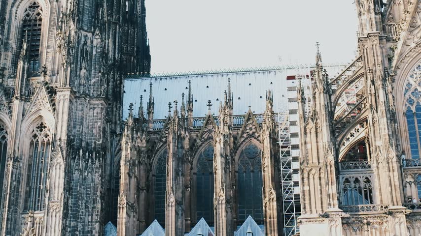 Close-up detailed view of the ornate gothic facade and spires of the iconic Cologne Cathedral Kolner Dom under a bright sky in Cologne, Germany