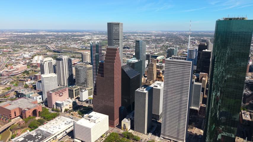 Downtown Houston skyline from above on clear sunny day. Modern skyscrapers and transportation corridors shape this iconic Texas city.
