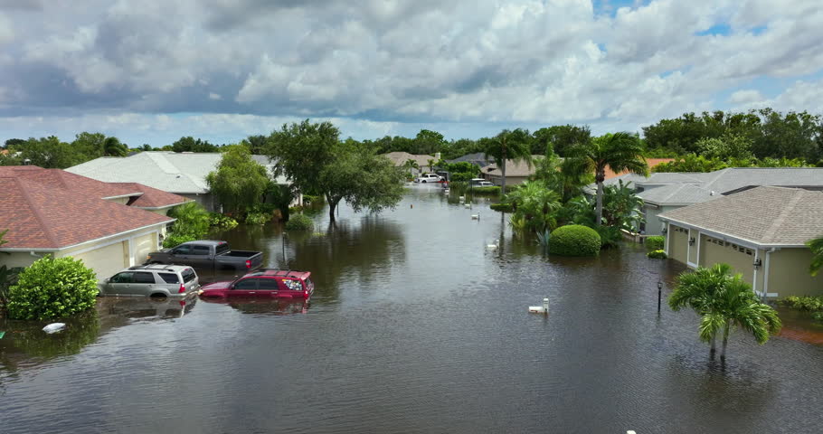 Flooded houses and cars from hurricane rainfall water in Florida residential community. Aftermath of natural disaster in USA south