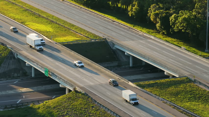 Highway overpass in countryside area with flowing traffic and structured on-ramps