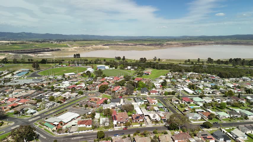 Morwell, Victoria, Australia – 4K aerial drone view of Latrobe Valley regional city, traffic, shops and houses, divided roads, railway corridor, residential neighbourhoods and urban infrastructure