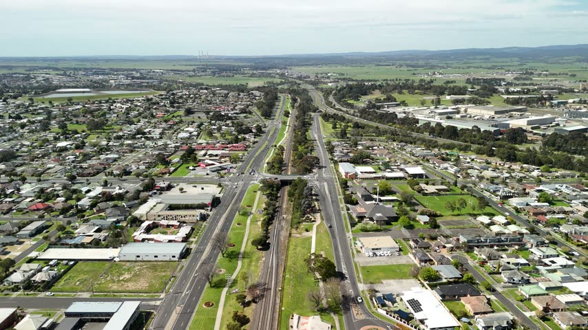 Morwell, Victoria, Australia – 4K aerial drone view of Latrobe Valley regional city, traffic, shops and houses, divided roads, railway corridor, residential neighbourhoods and urban infrastructure