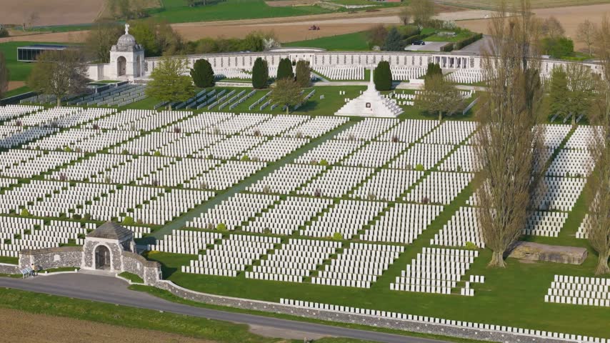 dense regimented white headstones converge cross sacrifice arched entrance pavilion curved memorial wall belgian countryside stretch quietly beyond cemetery toward tyne cot wwi