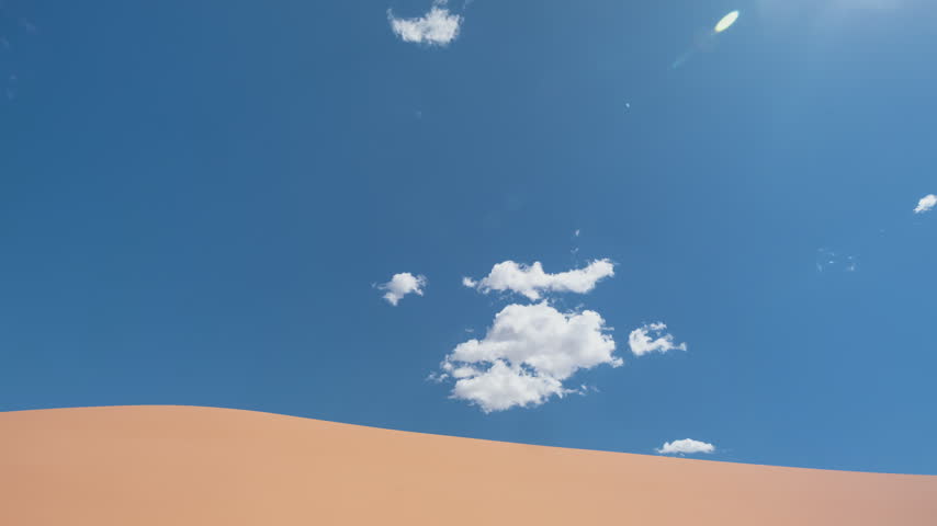 Time-lapse of clouds Moving Over Pink Coral Sand Dunes Utah Desert.