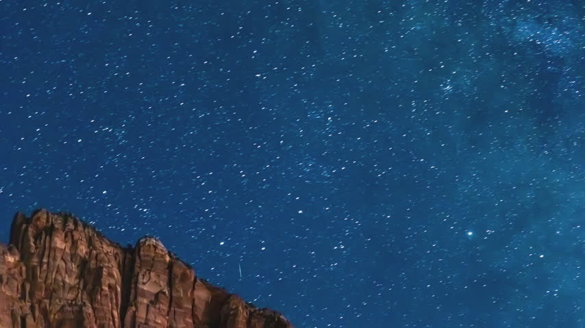 Time-lapse of stars over red rock cliffs in Zion National Park on a summer night.