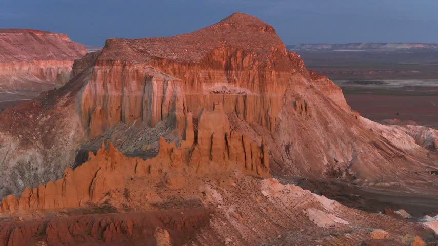 A close rising aerial passes narrow rock towers toward Airakty
