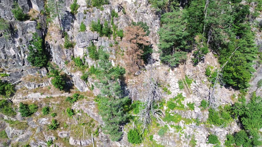 People Climbing Steep Cliffside Ladders at Mikaelshulen Cave in Norway