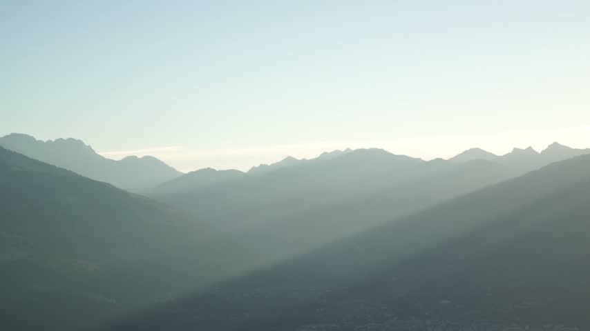 Swiss Mountain Landscape at Sunset
A picturesque mountain landscape in Switzerland at sunset. Sunlight streams through the clouds, creating striking beams of light that emphasize the depth of the mountain scenery. The soft light falls across the mountain slopes, highlighting different layers and creating a sense of depth and vastness. The blue tones of the mountains blend harmoniously with the warm glow of the setting sun, conveying an atmosphere of grandeur, tranquility, and natural beauty.