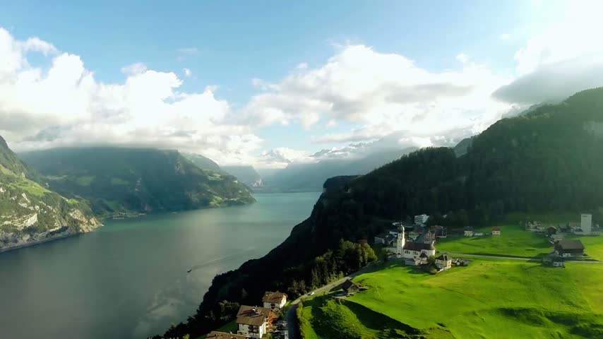 Aerial footage of Lake Lucerne in central Switzerland, showcasing crystal-clear lake waters, the surrounding Swiss Alps, dramatic mountain scenery, and a breathtaking panoramic landscape.