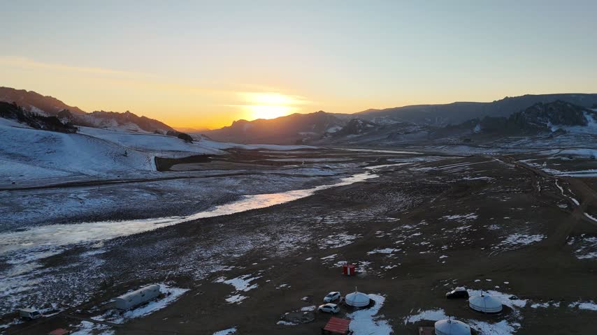 Traditional Mongolian Gers and Livestock in a Snowy Winter Landscape