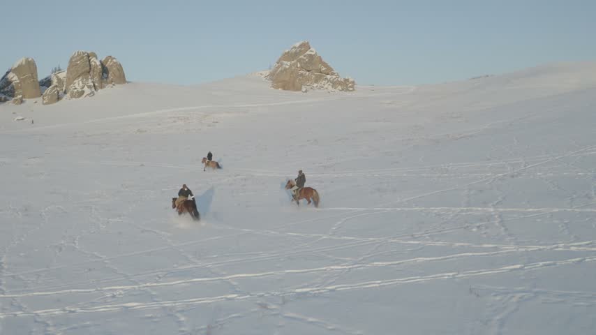 Mongolian Man Riding a Horse Through a Snowy Winter Landscape