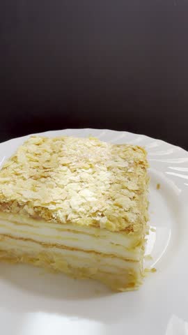 Piece of Napoleon cake on a plate. Slice of Mille-Feuille pastry on a plate.