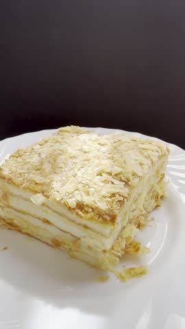 Piece of Napoleon cake on a plate. Slice of Mille-Feuille pastry on a plate.