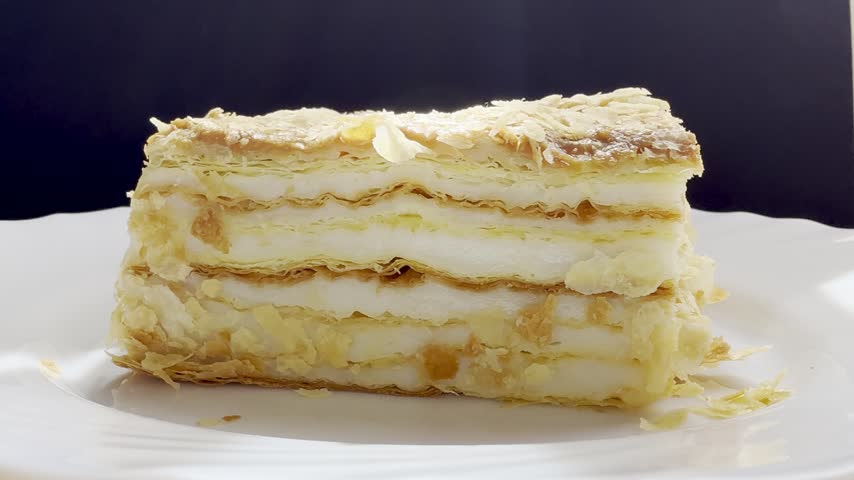 Piece of Napoleon cake on a plate. Slice of Mille-Feuille pastry on a plate.