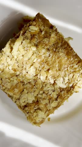 Piece of Napoleon cake on a plate. Slice of Mille-Feuille pastry on a plate.