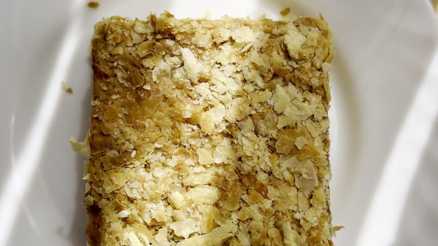 Piece of Napoleon cake on a plate. Slice of Mille-Feuille pastry on a plate.