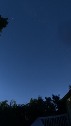 Starry Night Sky with Star Trails Over Silhouetted Landscape