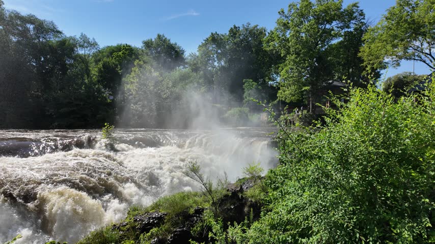 Powerful rapids flowing at Paterson Great Falls on a clear day