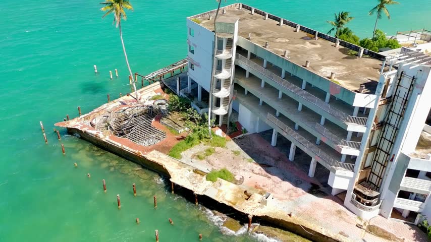 Drone video of an abandoned hotel next to the shore suffering from high sea levels and global warming in Puerto Rico.