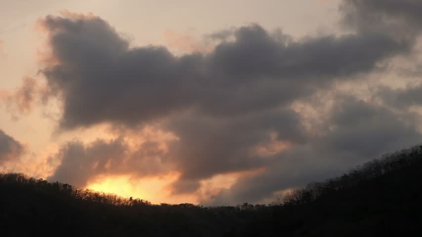Soft moving clouds over mountain silhouettes during a serene sunset. Perfect for meditation backgrounds, weather sequences, and peaceful nature projects