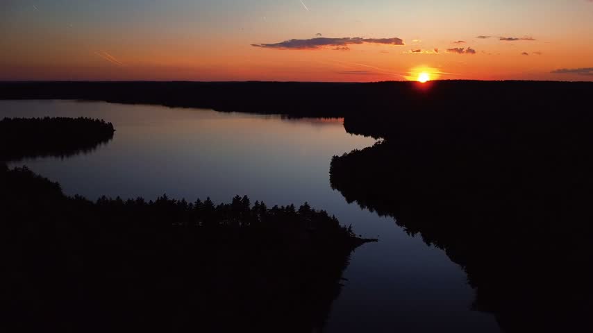 aerial view over still lake heading into the sunset