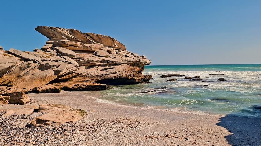 Beach cove with interesting rock formations and waves roll onto the sand