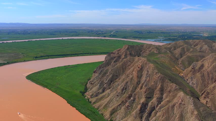 Muddy Yellow River flowing through mountain canyon in Wuzhong, Northwest China
Natural scenery of Yellow River valley with alluvial plain and lush vegetation