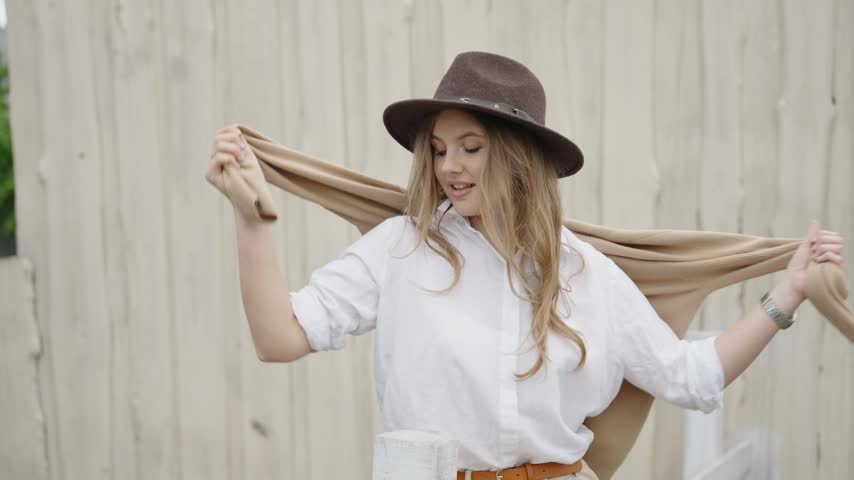 Stylish young woman in a hat posing outdoors