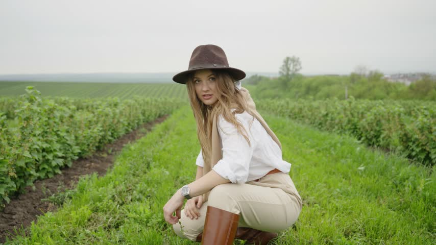 Beautiful farmer woman admiring the green field