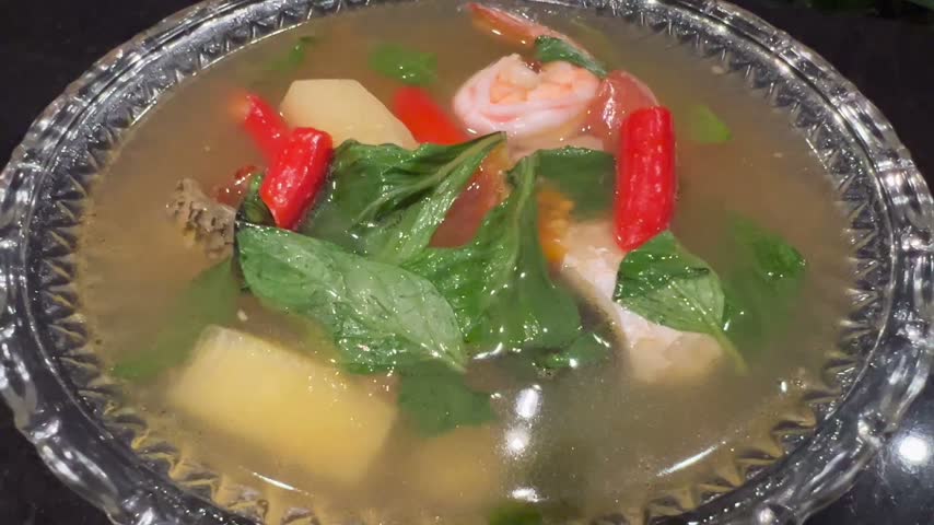 Thai Shrimp Soup with Red Chilies, Tomatoes and Fresh Herbs in a Glass Bowl