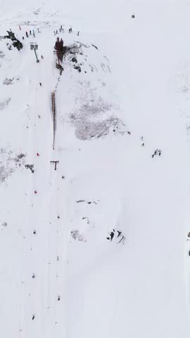 Aerial view of skiers on the snowy slopes of the Hemsedal Ski Resort with ski lifts and mountain terrain in Hemsedal, Buskerud, Norway.