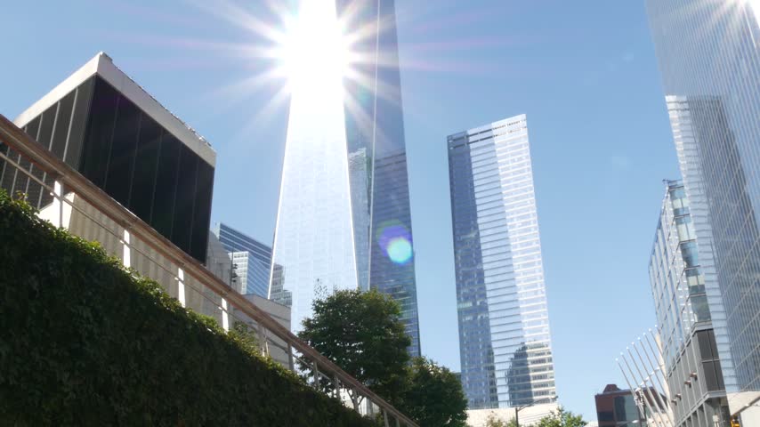 New York City Manhattan Downtown Financial District, United States of America. World Trade Center skyscraper, tower building in FiDi. Low angle from Liberty street. Modern business center. Sun rays.