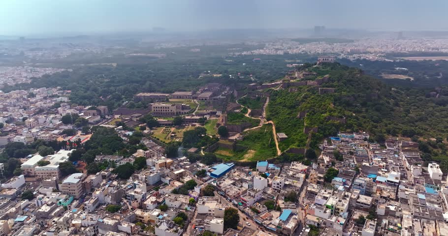 Aerial drone view of the historic Golconda Fort in Hyderabad, Telangana, India, showcasing its impressive stone fortifications, ancient architectural structures, and sprawling historic complex.