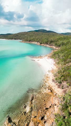 Aerial view of the turquoise waters and white sandy beaches of the Whitsundays coastline in Whitsundays, Queensland, Australia.