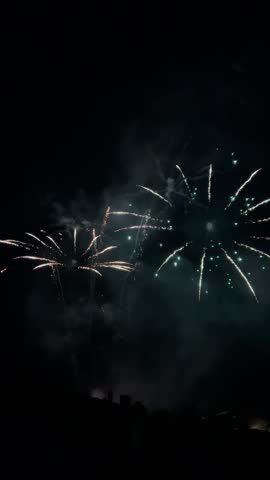 Vibrant fireworks show illuminating the dark night sky over a city during a celebration in Olot, Spain