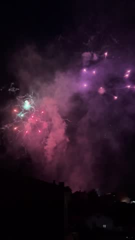 Colorful fireworks from a local festival illuminating the dark sky above a spanish town
