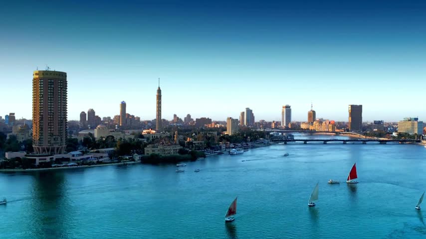 4K aerial view of Cairo, Egypt, showcasing the city skyline along the Nile River waterfront, with dense urban buildings and the expansive metropolitan landscape of Egypt’s capital.